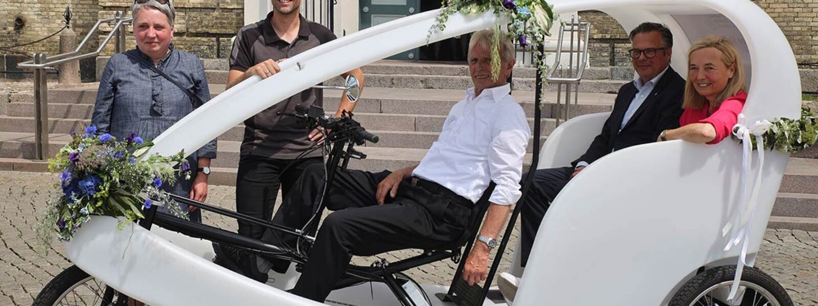 Braut und Bräutigam werden im Rad-Taxi nach kirchlicher Trauung in Husum gefahren